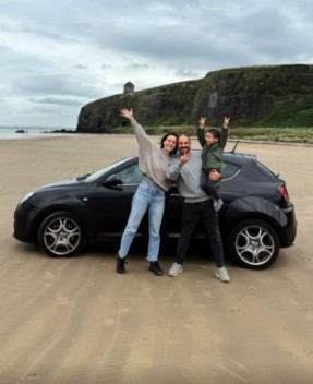 Mariangels y familia saludando en una playa junto a su coche